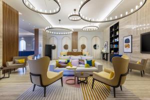 多哈voco Doha West Bay Suites, an IHG Hotel的客厅配有沙发和椅子