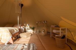 科尼尔-德拉弗龙特拉Glamping La Mimosa CONIL的一间卧室,配有带一张床和一张桌子的帐篷