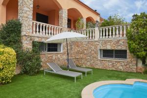 滨海阿雷尼斯Stay U-nique Villa Portimar II的房屋旁的天井配有2把椅子和遮阳伞。