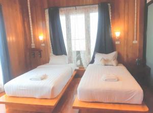 班武里府Srisanor Boutique Hotel的带窗户的客房内设有两张单人床。