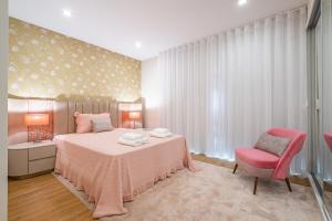 丰沙尔Urban Paradise by Madeira Sun Travel的卧室配有粉红色的床和粉红色的椅子