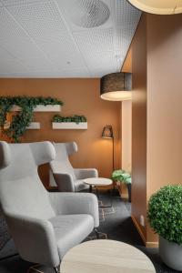 卑尔根Citybox Bergen City的一间设有椅子和墙上植物的等候室