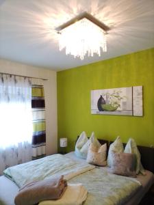 费尔德巴赫Ferienwohnung Krenn的一间卧室配有一张带绿色墙壁和吊灯的床。