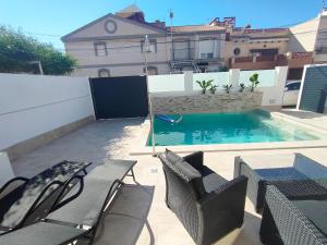 圣佩德罗-德尔皮纳塔尔Villamolinos, villa con piscina privada.的后院设有游泳池、椅子和房屋