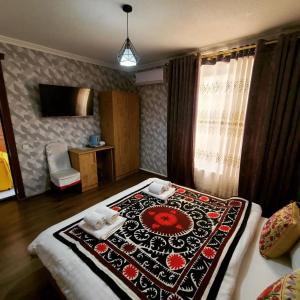 撒马尔罕Samarkand City Center Hotel的一间卧室配有一张床铺,床上有毯子