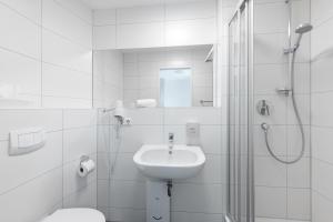 斯图加特Hotel Garni am Olgaeck的白色的浴室设有水槽和淋浴。
