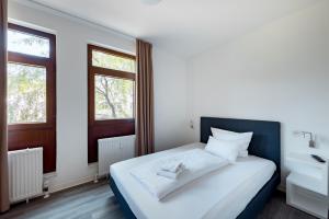 斯图加特Hotel Garni am Olgaeck的一间卧室设有一张大床和两个窗户。