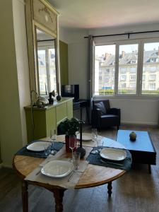 亚眠Sòlfar - Amiens (hypercentre)的客厅配有带盘子和玻璃杯的桌子