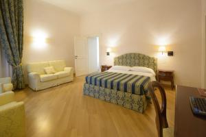 安科纳Domus Stella Maris - Casa per Ferie的一间卧室配有一张床、一张沙发和一把椅子