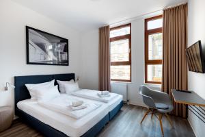 斯图加特Hotel Garni am Olgaeck的卧室配有一张床、一张书桌和窗户。