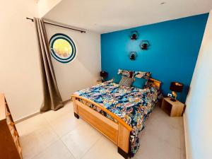 PoncinsLa Villa Perroquet的一间卧室配有一张蓝色墙壁的床