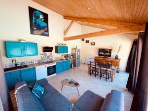 PoncinsLa Villa Perroquet的带沙发的客厅和带蓝色橱柜的厨房。