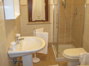 StronconeLa Casetta Arancione appartamento的一间带水槽、卫生间和淋浴的浴室