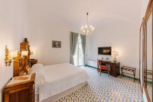 拉维罗佐丹奴酒店的一间卧室配有一张床、一张书桌和一台电视