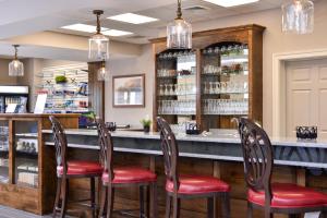 AppomattoxAppomattox Inn and Suites的餐厅里设有红色座位的酒吧