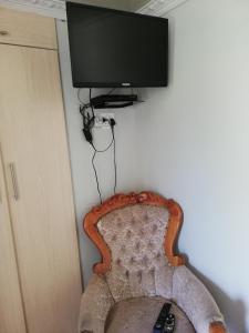 昆斯敦Nonesi Lodge的挂在墙上的平板电视,带椅子