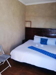 昆斯敦Nonesi Lodge的卧室配有白色的床和椅子