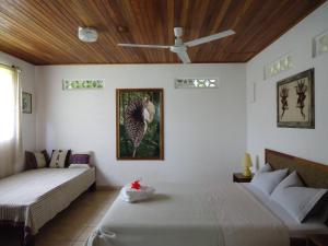 La Garita费尔南多住宿加早餐旅馆的一间卧室配有两张床和吊扇