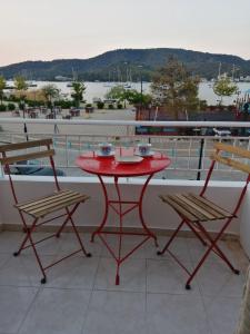 加拉塔斯Waterway view的阳台上配有一张红色的桌子和两把椅子