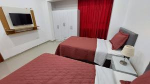 瓦努科Departamentos amoblados en Huánuco的酒店客房设有两张床和电视。