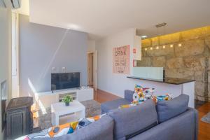 波尔图Feel Porto Ribeira Vintage Duplex的客厅设有蓝色的沙发和石墙