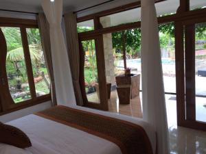MayongThe Aroma Villa Munduk的一间卧室配有一张床,享有游泳池的景色