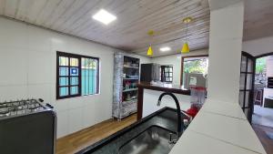 马利西亚斯Casa Paúba 80m do Mar的一间位于客房中间的带水槽的厨房