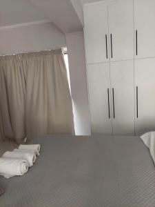 扎金索斯镇Alexandra's Apartments - Port of Zante的一间卧室配有一张床、白色橱柜和窗户。