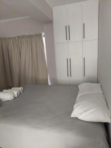 扎金索斯镇Alexandra's Apartments - Port of Zante的一间卧室配有一张带白色橱柜的床。