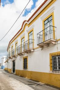 CanoEighteen21 Houses - Casa dos Condes的白色和黄色的建筑,在街上设有阳台