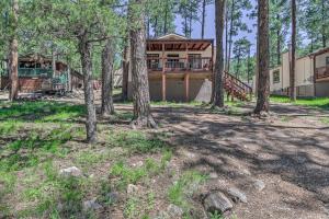 鲁伊多索Pet-Friendly Ruidoso Home with Deck and Forest Views!的林中树木林立的房屋