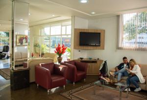 伊瓜苏Hotel Dan Inn Express Foz do Iguaçu的坐在客厅的男人和女人