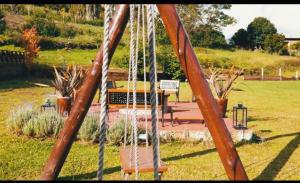 格拉玛多Palast Haus Pousada的公园内摆有长凳的秋千