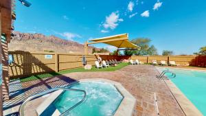 摩押Desert Hideaway #C2的后院设有游泳池和带遮阳伞的庭院。