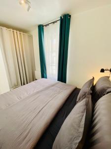 蒙雷里Superbe appartement 2 pièces, plein centre ville.的一间卧室配有一张带蓝色窗帘的床和一扇窗户