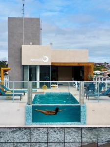 马塞约Hotel Água de Coco的躺在建筑物屋顶游泳池的人