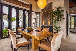乌干沙Nusa Dua Ocean Cliff Dream的一间带木桌和椅子的用餐室