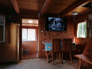 StrážChata Florián的一间设有桌子和墙上电视的用餐室