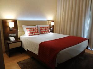 法鲁摩纳哥酒店的一间卧室配有一张带红色毯子的大床