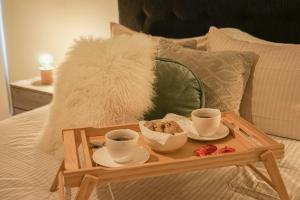 利马Chic Executive Apartment-Barranco的床上的木托盘,上面放着两杯咖啡