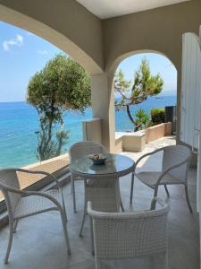 GázionBeautiful House in Front of the Sea的一个带桌椅的庭院和大海