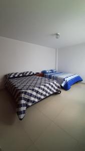 锡帕基拉Apartamentos Turisticos EL ZIPA的两张睡床彼此相邻,位于一个房间里