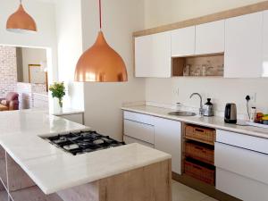 斯瓦科普蒙德Beach Garden Guesthouse with Self Catering的厨房配有白色橱柜和炉灶烤箱。