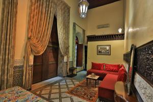 非斯Riad Moulaydriss et Giacomo的客厅配有红色沙发和门