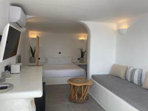 费拉诺米科斯别墅酒店的一间卧室配有一张床、一张桌子和一张桌子
