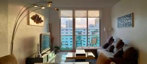 迈阿密海滩海洋保护区顶层公寓的带沙发和大窗户的客厅