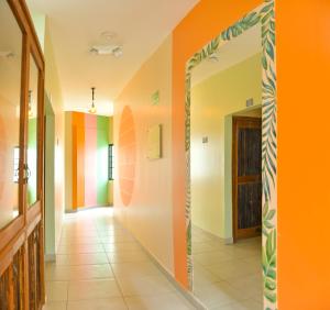 圣玛尔塔Distrito Hostel的走廊上设有橙色墙壁和镜子