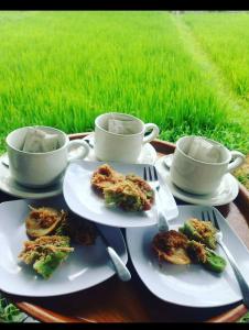 Tirtagangga谷米巴厘旅馆的餐桌,盘子,杯子,田野