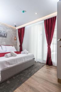 萨拉热窝Mayisa Apartments的一间卧室设有两张床和红色窗帘