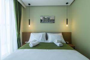萨拉热窝Mayisa Apartments的卧室配有带白色枕头的大床